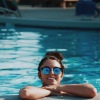 woman in a pool with sunglasses on